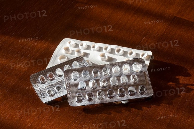Empty blister packs on a brown wooden surface