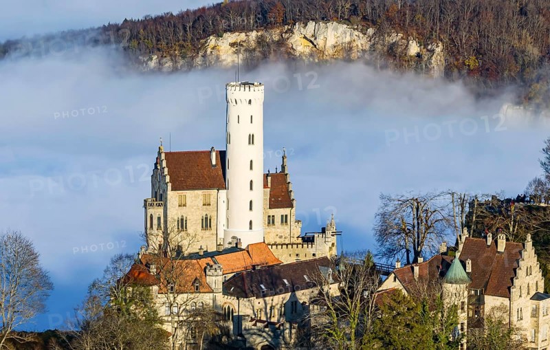 Sunshine in the mountains, fog in the Echaz valley. Lichtenstein Castle in the Swabian Alb. The fairytale castle of Württemberg is a 19th century castle built in the historicist style. Aerial photo. Lichtenstein, Baden-Württemberg, Germany, Europe
