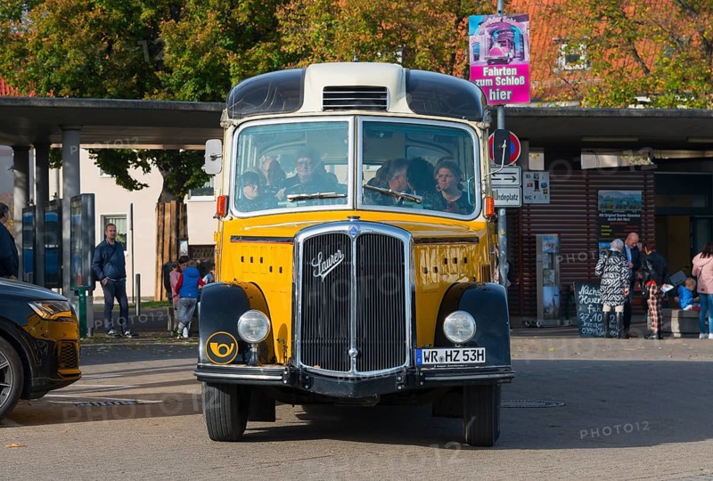 Front view of a yellow vintage bus with people in an urban environment, vintage car, Saurer, Postbus, Alpen-Postbus L4C, year of construction 1953, Wernigerode, Harz, Saxony-Anhalt, Germany, Europe