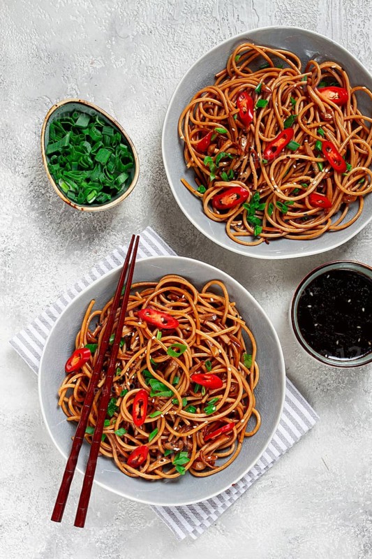 Udon noodles, with shimeji mushrooms, vegetables, in sauce, with sesame seeds, green onions, Asian vegetarian food, horizontal, without people