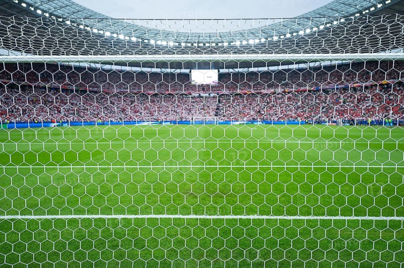 BERLIN, GERMANY - JULY 6, 2024: Euro 2024 quarterfinal match Nederlands vs Turkey. Detail of goal's net and football match in the background.