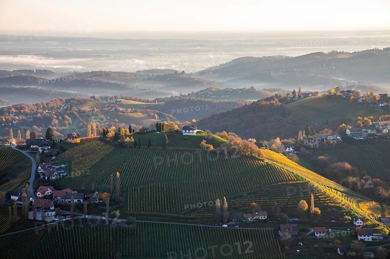 Morning atmosphere, morning light falls on hilly landscape and vineyards, early morning mist in the valley, view from the Demmerkogel viewing platform, St. Andrä-Höch, Sausal wine country, Styria, Austria, Europe
