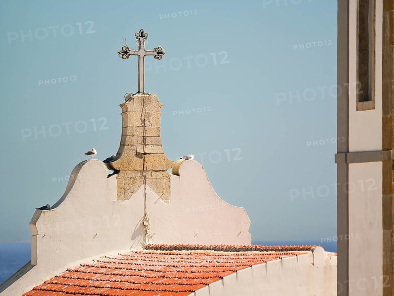 Mother Church cross and rooftop with sky and ocean in the background, Albufeira, Algarve, Portugal, Europe