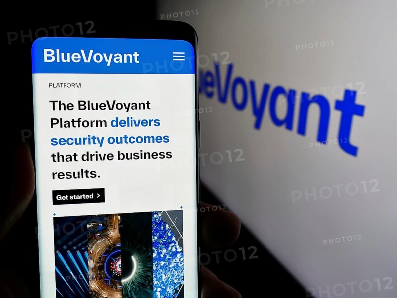 Stuttgart, Germany, 04-02-2024: Person holding mobile phone with web page of US cyber defense platform company BlueVoyant LLC in front of logo. Focus on center of phone display, Europe