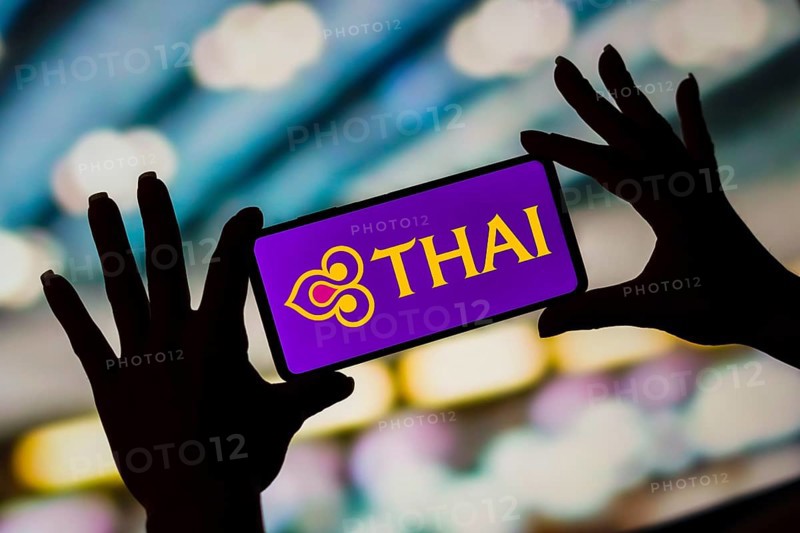In this photo illustration, the Thai Airways International logo is displayed on a smartphone screen
