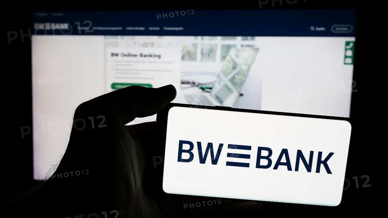 Stuttgart, Germany, 07-15-2024: Person holding mobile phone with logo of German company Baden-Württembergische Bank (BW-Bank) in front of web page. Focus on phone display, Europe