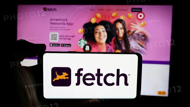 Stuttgart, Germany, 07-14-2024: Person holding cellphone with logo of US reward app company Fetch Rewards LLC in front of business webpage. Focus on phone display, Europe