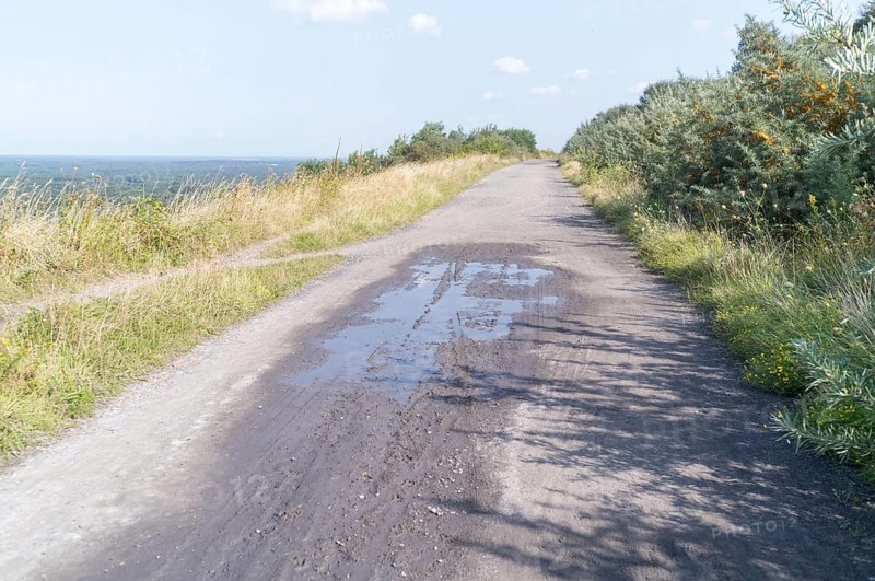 Wide gravel path on a hill with a distant view