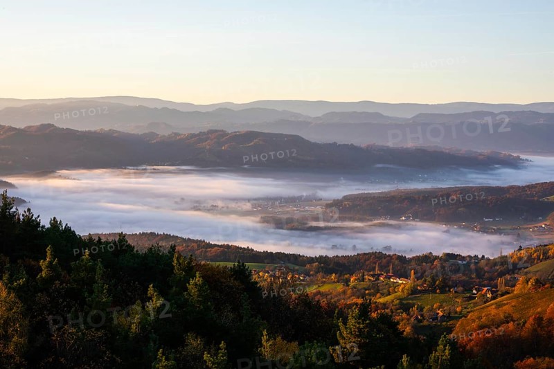 Autumn atmosphere in the morning light, fog drifts over forest with foliage colouring, vineyards and hilly landscape, view from the Demmerkogel lookout point, St. Andrä-Höch, Sausal wine country, Styria, Austria, Europe