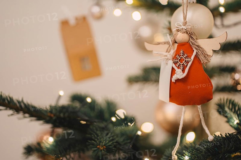 Christmas decorations on the Christmas tree, artificial angel. Christmas warm mood. Background lights