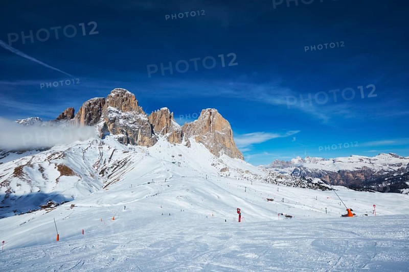 View of a ski resort piste with people skiing in Dolomites in Italy
