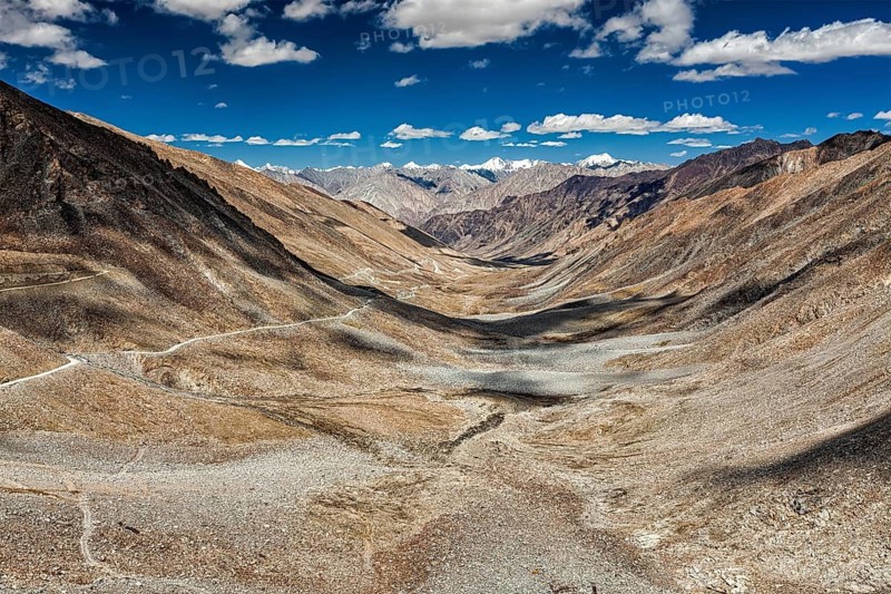View of Karakoram range and road in valley from Kardung La, the highest motorable pass in the world (5602 m) in Himalayas. Ladakh, India, Asia