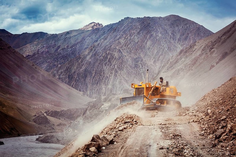 LADAKH, INDIA, SEPTEMBER 10, 2011: Bulldozer cleaning road after landslide in Himalayas. Ladakh, Jammu and Kashmir, India, Asia