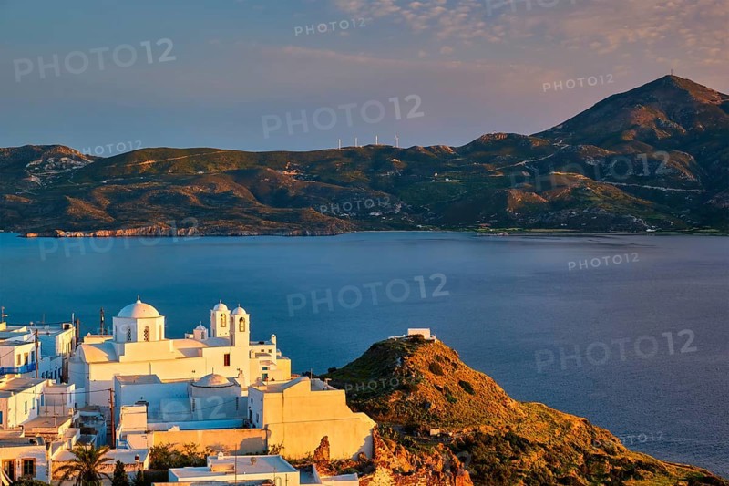 View of Plaka village on Milos island with traditional greek white houses with Greek Orthodox christian churck on sunset. Plaka town, Milos island, Greece, Europe