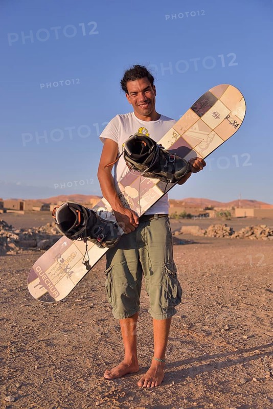 Man holding a sandboard, sandboarder, Sahara, Merzouga, Meknès-Tafilalet region, Morocco, Africa