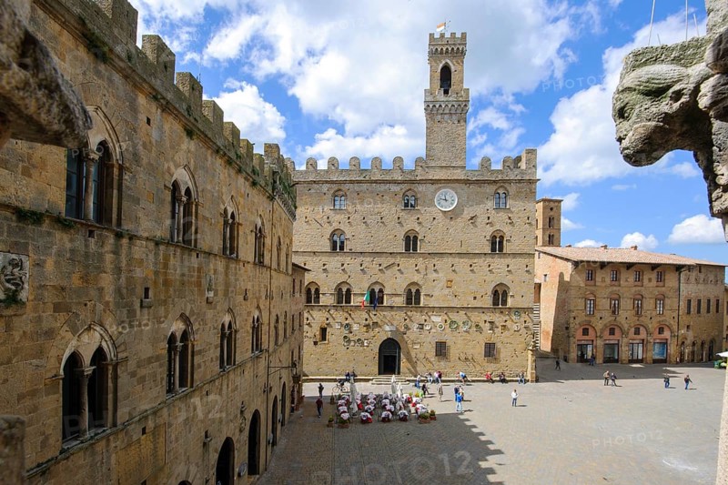 View of historical building from the Middle Ages Palazzo dei Priori town hall of Volterra built in 1208, 13th century, right foreground old symbolic figure on house corner, Volterra, Tuscany, Italy, Europe