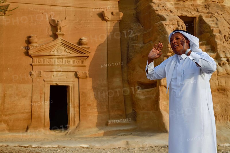 Rawi, storyteller, in front of the Nabataean tombs at the rock Qasr Al-Bint, Hegra or Madain Salih, AlUla region, Medina province, Saudi Arabia, Arabian Peninsula, Asia