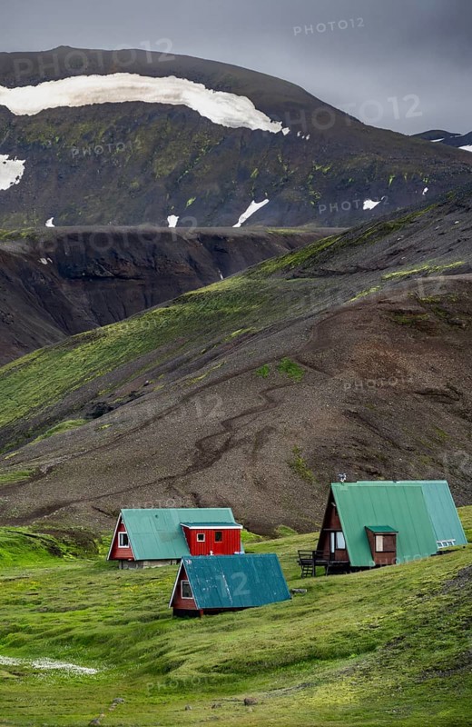 Cabins among volcanic landscape with black sand and green grass, Ásgarður, Kerlingarfjöll, Icelandic Highlands, Iceland, Europe