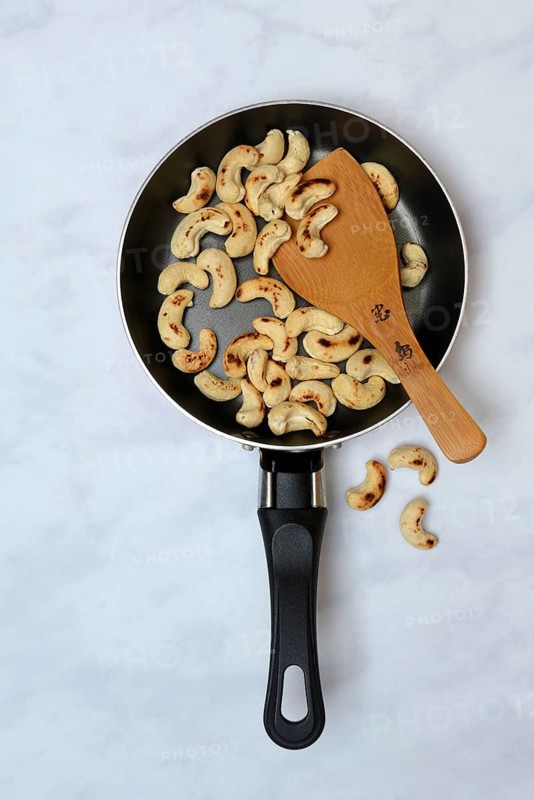 Cashew, roasted cashew kernels in pan with ladle