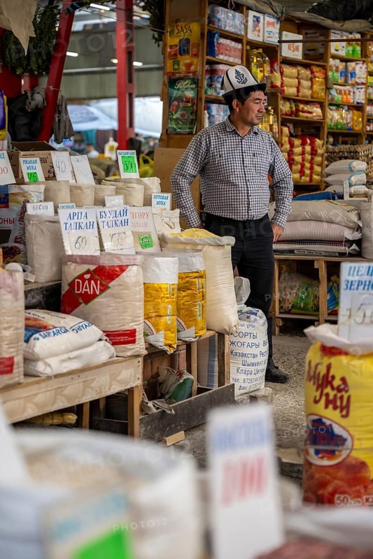 Traditional man selling spices, flour and food, market stall at Osh Bazaar, Bishkek, Kyrgyzstan, Asia
