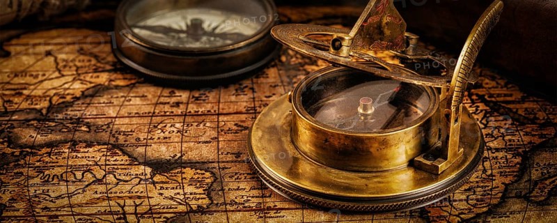 Travel geography navigation concept background, letterbox panorama of old vintage retro compass with sundial and spyglass on ancient world map with copyspace