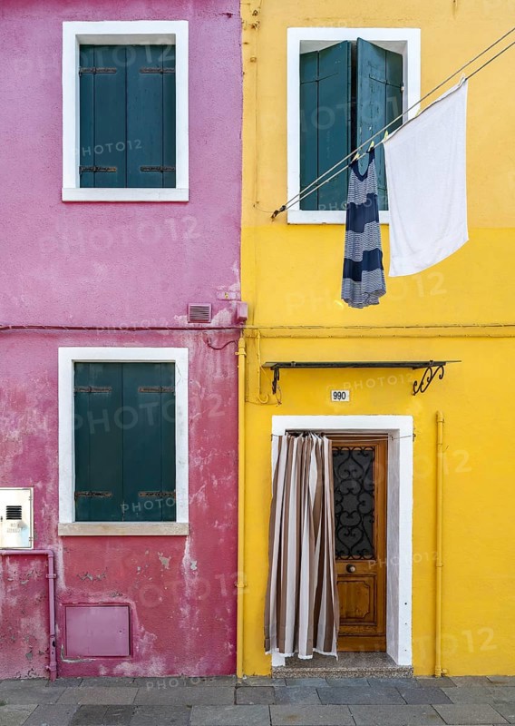 Purple and yellow house facade with entrance door and windows and clothesline, colourful houses on the island of Burano, Venice, Veneto, Italy, Europe