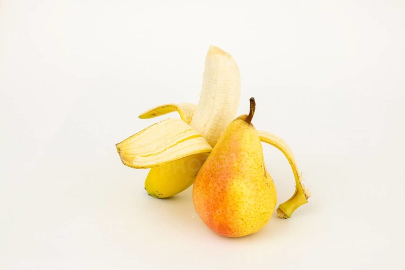 Half peeled banana with pear, studio shot, white background, healthy food