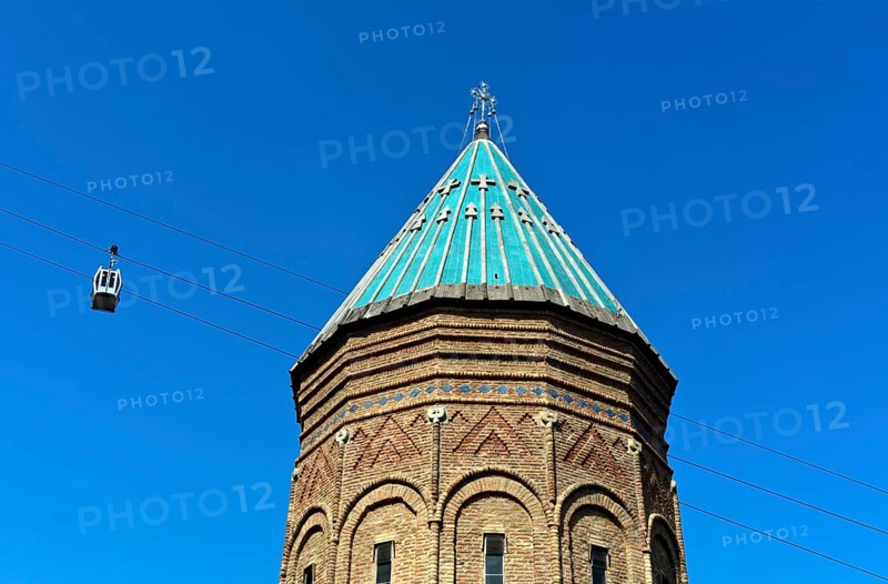 Two cabins of the Rike-Narikala cable car pass the tower of St George's Armenian Church, Tbilisi, Georgia, Asia