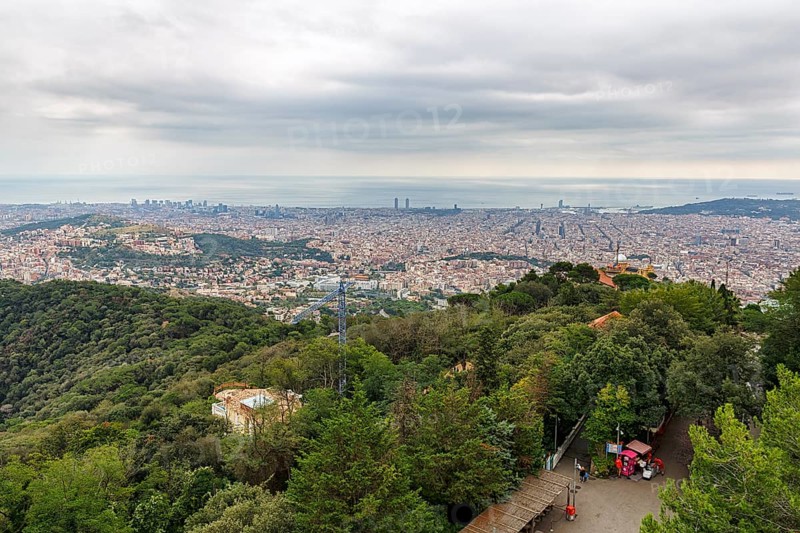 View of the sea of houses up to the coast, cloudy sky in autumn, haze, Tibidabo, Barcelona, Spain, Europe