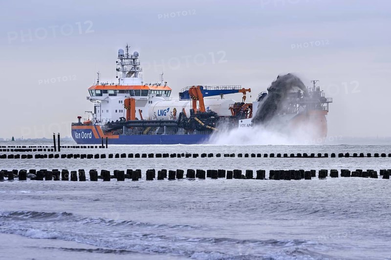 Trailing suction hopper dredger Vox Apolonia of Van Oord, Dutch maritime contracting company specialized in dredging, rainbowing along Zeeland coast