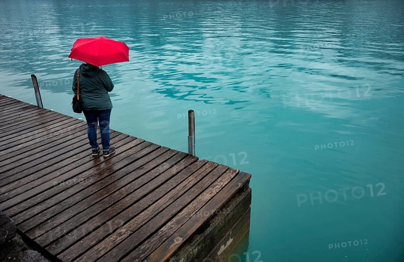 Older woman, best-ager, with red umbrella, bad weather, lakeside promenade at Lake Brienz, Brienz, Canton Bern, Bernese Oberland, Switzerland, Europe