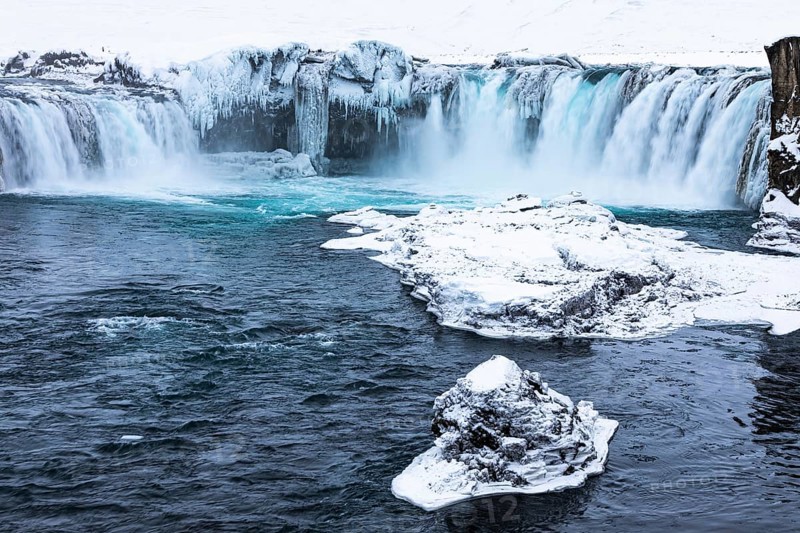 Ice layer in the river Skialfandaljot, behind it the waterfall Godafoss, Northern Iceland Eyestra, Iceland, Europe
