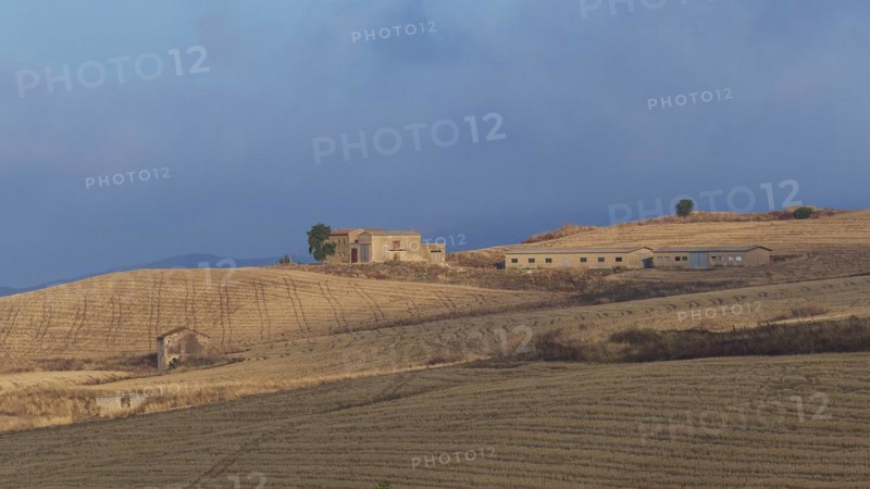 Dry hilly landscape, fields, farmstead, building, blue cloudy sky, Madonie National Park, autumn, late summer, Sicily, Italy, Europe