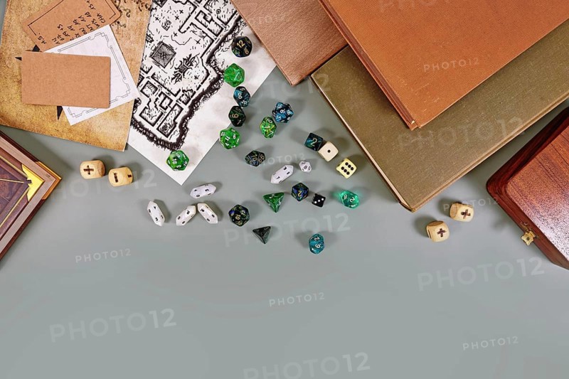 Tabletop roleplaying flat lay with RPG and game dices, rule book, notes and treasure map on gray background with copy space