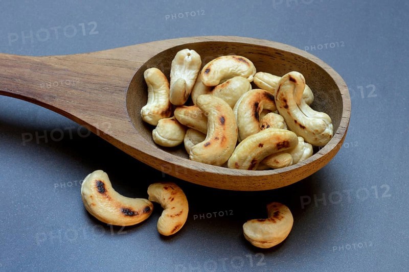 Cashew, roasted cashews in wooden ladle