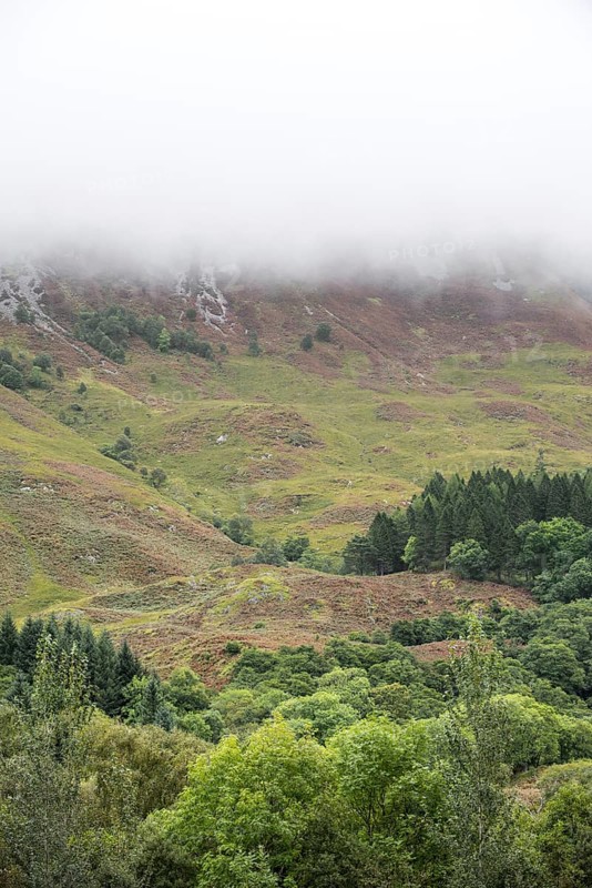 Rain cloud forming thick fog descending from steep hillside of Bidean nam Bian in Glen Coe, Argyll, Scottish Highlands, Scotland, United Kingdom, Europe