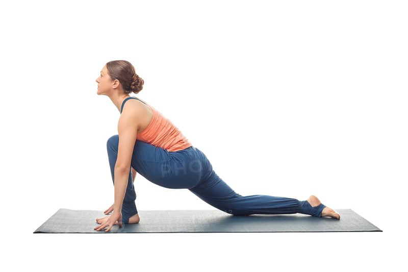 Beautiful sporty fit yogini woman practices yoga asana Anjaneyasana, low crescent lunge pose in surya namaskar isolated on white