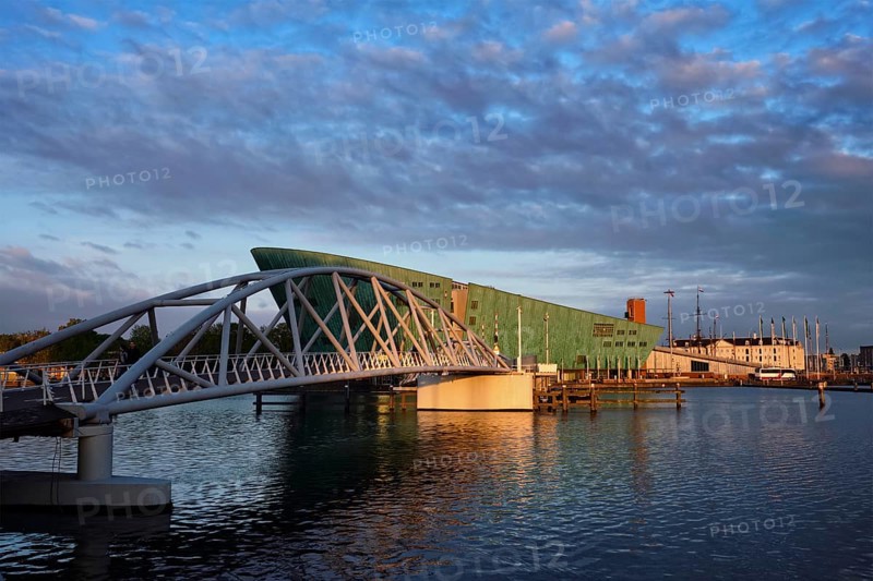 AMSTERDAM, NETHERLANDS, MAY 9, 2017: NEMO Science museum and Mr. J. van der Veldebrug bridge. It is the largest science center in Netherlands with over 500000 visitors per year