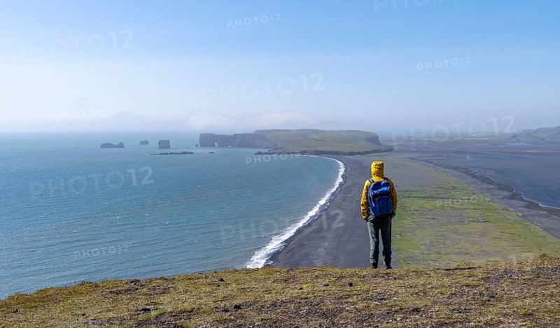 Tourist on rocky coast, view over Reynisfjara beach, black sand beach, Vik, South Iceland, Iceland, Europe