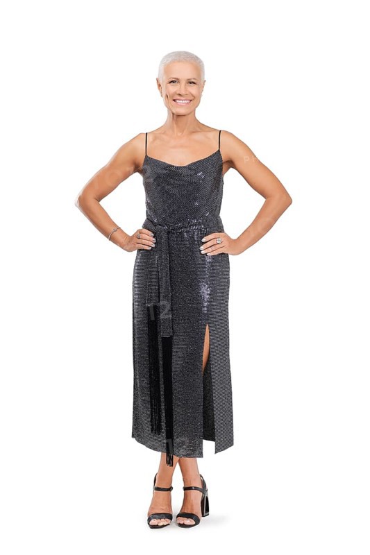 Full length portrait of smiling middle-aged woman in cocktail dress with hands on waist