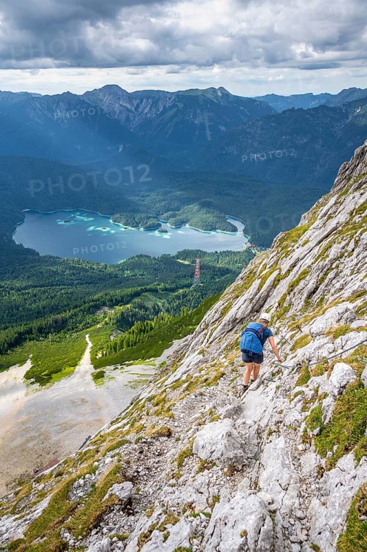 Via ferrata over the Riffelscharte, hiker in the mountains, view of Eibsee lake and Werdenfelser Land, Wetterstein Mountains, Garmisch-Patenkirchen, Bavaria, Germany, Europe