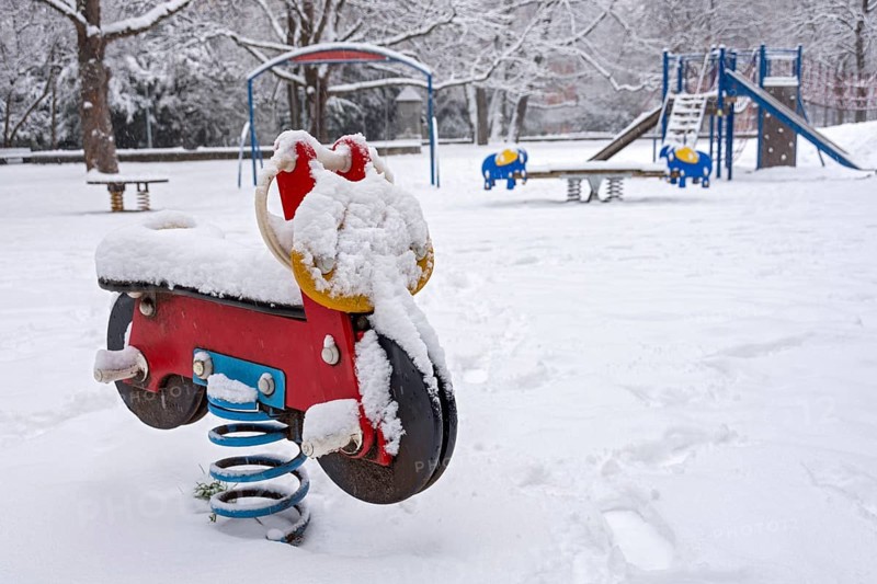 Seesaw motorbike, spring seesaw for children, snow on playground in winter, Nußbaumpark, Altstadt, Munich, Upper Bavaria, Bavaria, Germany, Europe