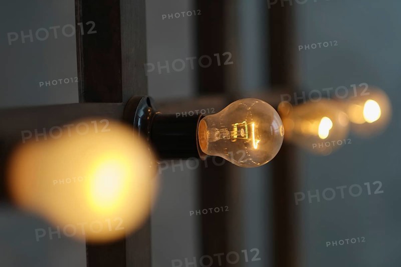 Old edison lamp mounted on wooden background