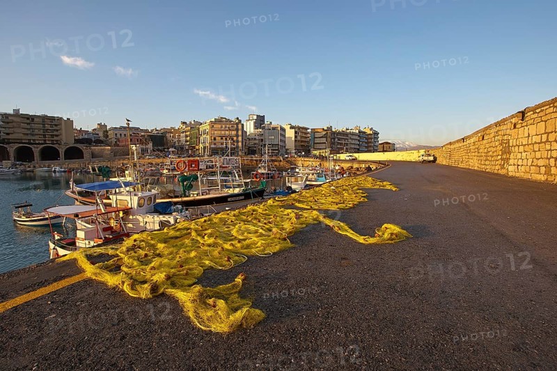 Morning light, yellow fishing nets, fishing boats, houses, blue sky, few white clouds, harbour, Heraklion, capital, island of Crete, Greece, Europe