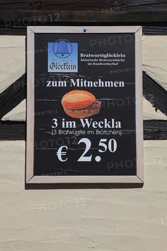 In the old town of Nuremberg, advertising sign of the restaurant, Bratwurstglöcklein, three in the Weckla, three Nuremberg sausages in a roll, historic brew sausage kitchen in the Handwerkerhof, Middle Franconia, Bavaria, Germany, Europe