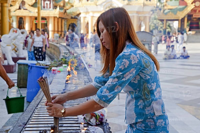Burmese girl burning incense sticks, joss sticks in the Shwedagon Zedi Daw Pagoda at Yangon, Rangoon, Myanmar, Burma, Asia