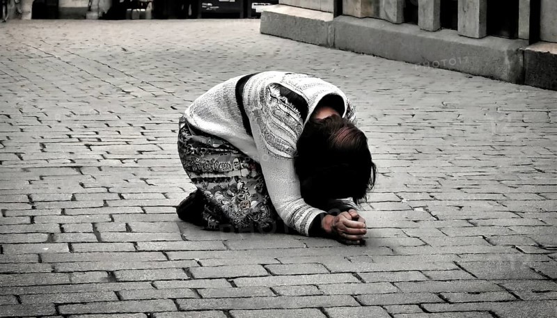Social hardship, Torn beggar woman with poor clothes in humble posture kneeling on the street, KI generated, AI generated