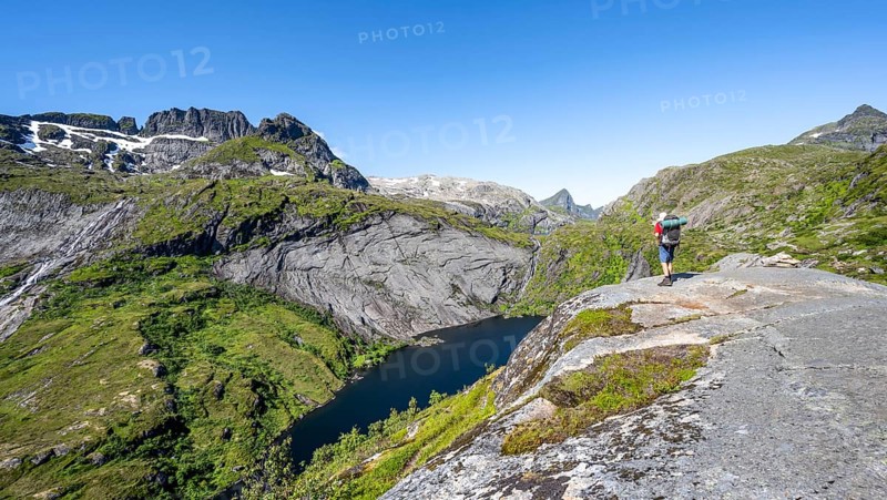Mountaineers on the hiking trail to Munkebu hut, view of lake Tridalsvatnet and mountain landscape, Moskenesøya, Lofoten, Nordland, Norway, Europe