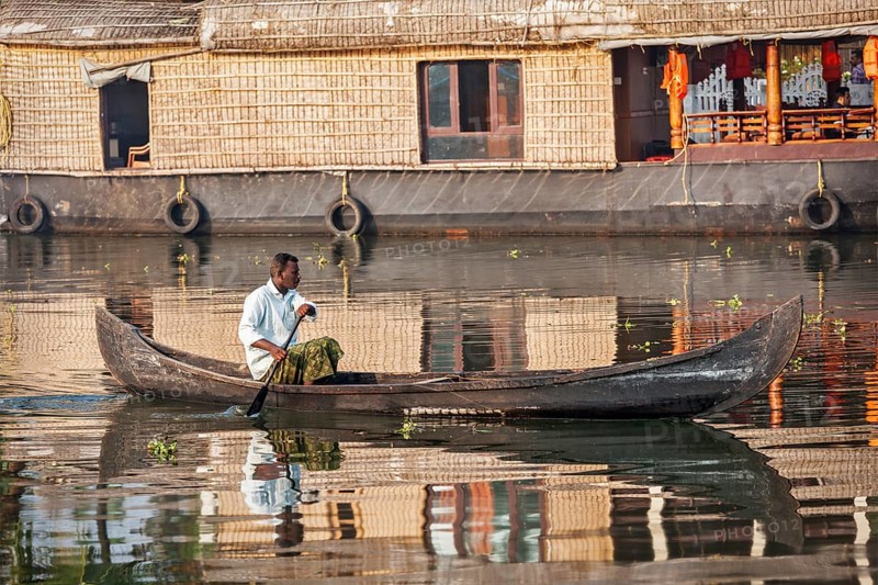 KERALA, INDIA, MAY 5, 2010: Unidentified indian man in small boat in backwaters. Kerala backwaters are both major tourist attraction and integral part of local people life in Kerala