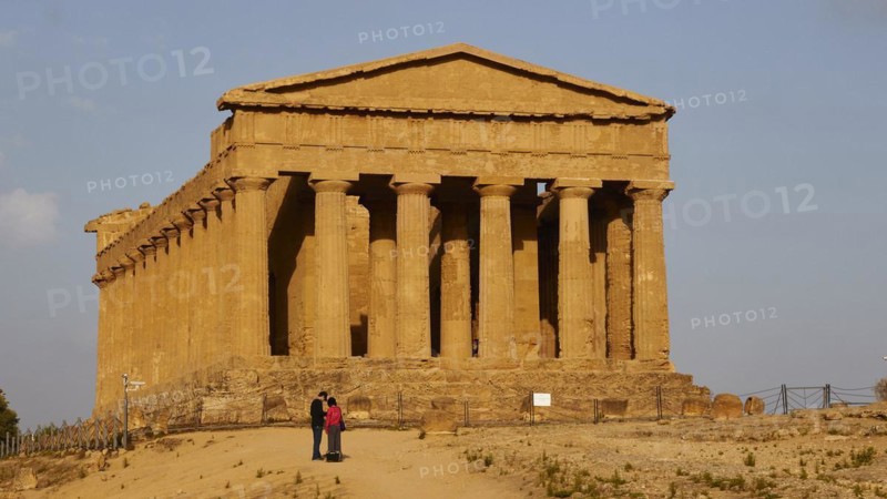 Evening light, Concordia temple, 2 visitors, front, valley of the temples, valle dei templi, Agrigento, Sicily, Italy, Europe